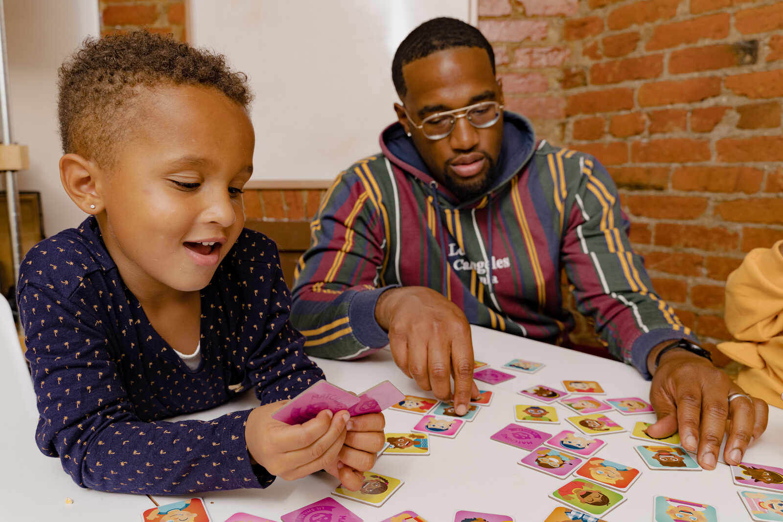 Two children reading together with a parent
